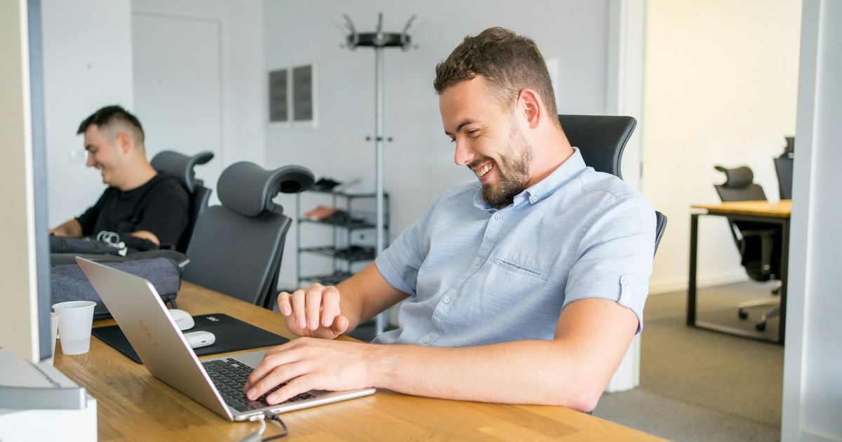 Deux salariés au travail sur leur ordinateur dans un bureau lumineux