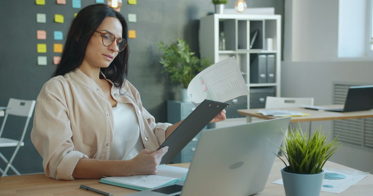 Une dirigeante relisant des documents à son bureau